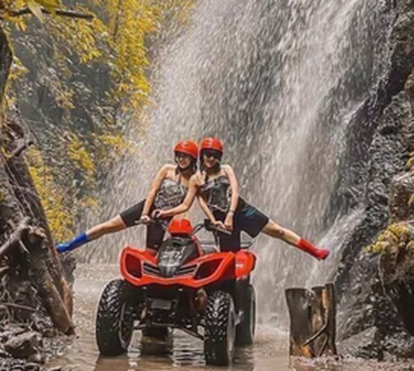 ATV parked in front of a jungle waterfall