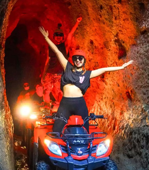 ATV rider inside a lit jungle tunnel in Bali