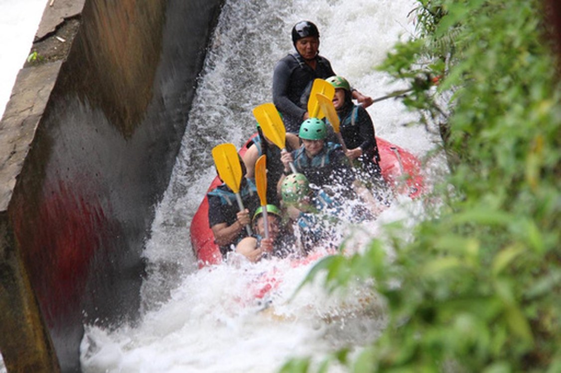 Raft passing under a river waterfall